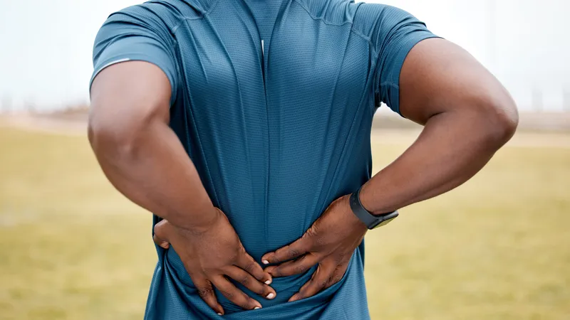 Person holding their lower back