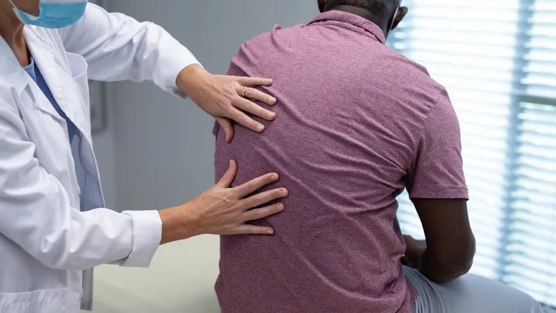 Clinician examining a patient’s back