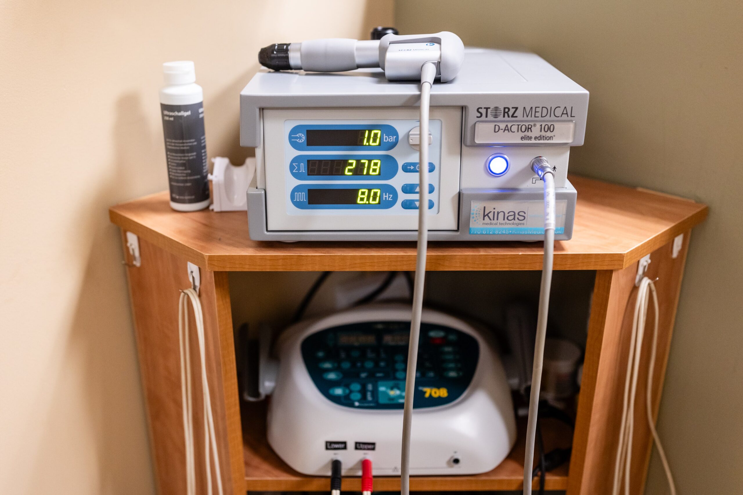 Medical therapy devices on a wooden cabinet in a clinical setting.