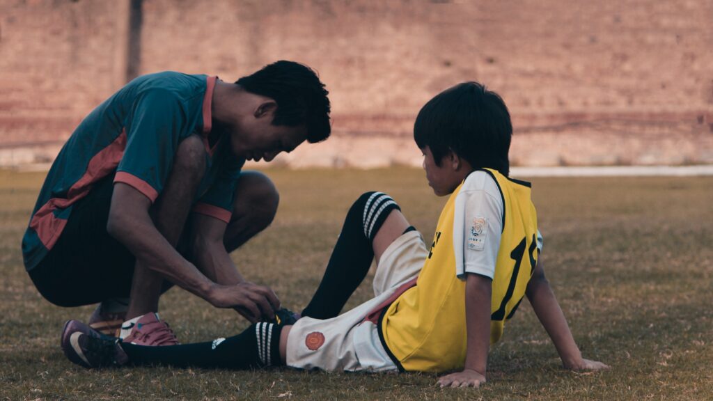 young adult tying a child's shoelace